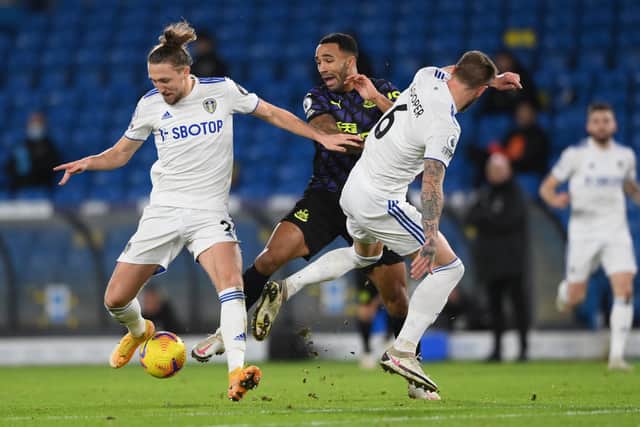 LEEDS, ENGLAND - DECEMBER 16: Callum Wilson of Newcastle United is challenged by Luke Ayling (l) and Liam Cooper of Leeds United during the Premier League match between Leeds United and Newcastle United at Elland Road on December 16, 2020 in Leeds, England.The match will be played without fans, behind closed doors as a Covid-19 precaution. (Photo by Stu Forster/Getty Images)