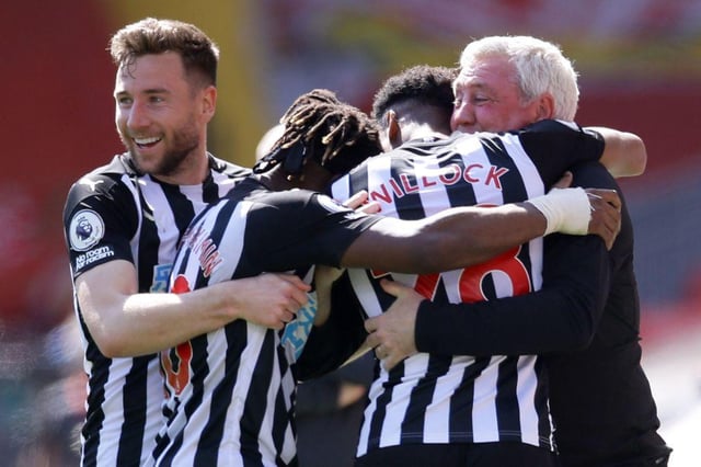 Joe Willock is embraced by Steve Bruce and his team-mates after scoring at Anfield.