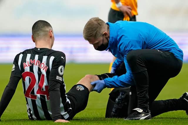 Miguel Almiron is treated after suffering a knee injury.