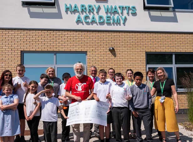 Les Milne from Save the Children with pupils from Harry Watts Academy