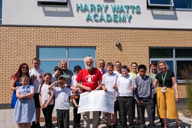 Les Milne from Save the Children with pupils from Harry Watts Academy