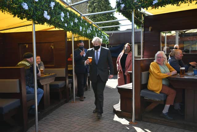 Prime Minister Boris Johnson carries a pint through a beer garden on the local election campaign trail. Picture: Jacob King - WPA Pool/Getty Images.
