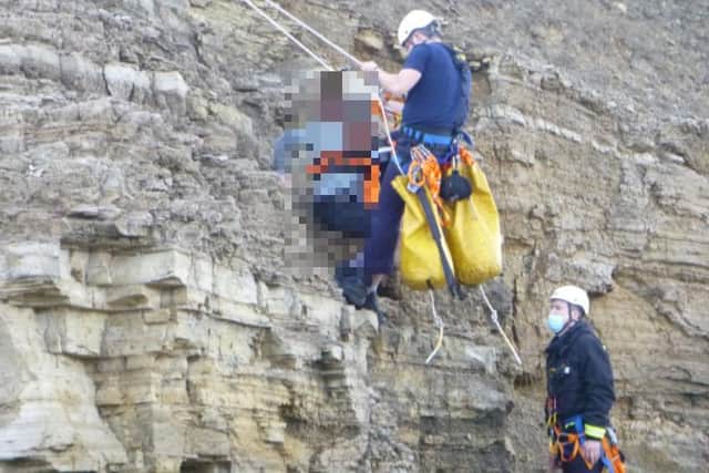 A boy was rescued from the cliff top by several emergency crews after getting stuck.