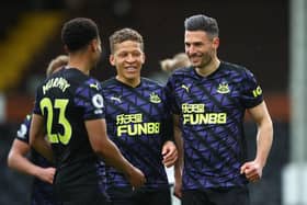 Fabian Schar of Newcastle United celebrates with Dwight Gayle and nu after scoring his sides second goal during the Premier League match between Fulham and Newcastle United at Craven Cottage on May 23, 2021 in London, England.