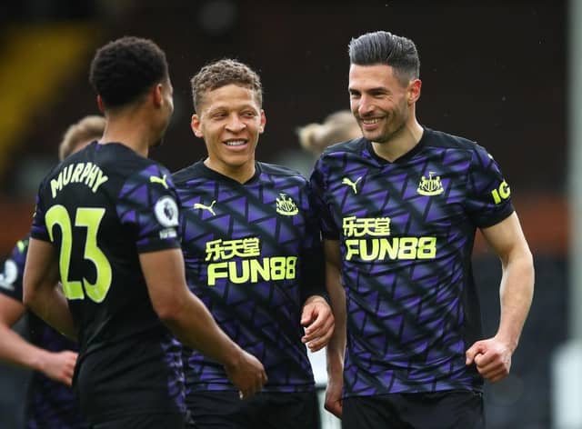 Fabian Schar of Newcastle United celebrates with Dwight Gayle and nu after scoring his sides second goal during the Premier League match between Fulham and Newcastle United at Craven Cottage on May 23, 2021 in London, England.