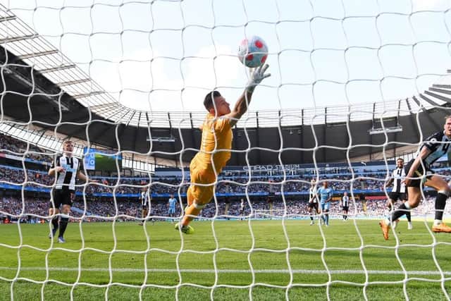 Newcastle United's Martin Dubravka attempts to stop the ball as Raheem Sterling scores Manchester City's first goal.