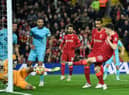 Liverpool's Portuguese striker Diogo Jota (R) shoots to score their first goal during the English Premier League football match between Liverpool and Newcastle United at Anfield in Liverpool, north west England on December 16, 2021. (Photo by OLI SCARFF/AFP via Getty Images)
