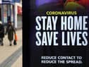 People walk past a 'Stay Home Save Lives' sign on Broadmead in Bristol during England's third national lockdown to curb the spread of coronavirus. Under increased measures people can no longer leave their home without a reasonable excuse and schools must shut for most pupils. PA Photo. Picture date: Saturday January 9, 2021. See PA story HEALTH Coronavirus. Photo credit should read: Andrew Matthews/PA Wire