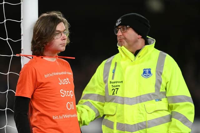 A fan ties himself to the net in protest during the Premier League match between Everton and Newcastle United at Goodison Park on March 17, 2022 in Liverpool, England. (Photo by Michael Regan/Getty Images)