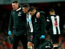 Newcastle United's Irish defender Ciaran Clark (C) is helped from the pitch after picking up an injury during the English Premier League football match between Arsenal and Newcastle United at the Emirates Stadium in London on February 16, 2020.