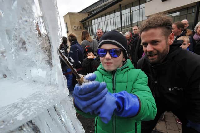 Harry Hallam carving the ice under the watchful eye of sculptor Matt Foster, at Durham's Fire and Ice Festival.