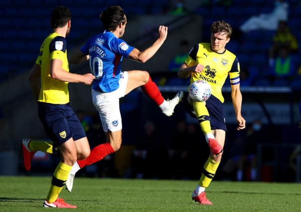 John Marquis of Portsmouth is challenged by Rob Dickie of Oxford United.