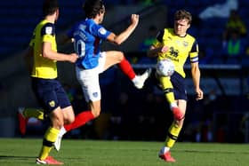 John Marquis of Portsmouth is challenged by Rob Dickie of Oxford United.