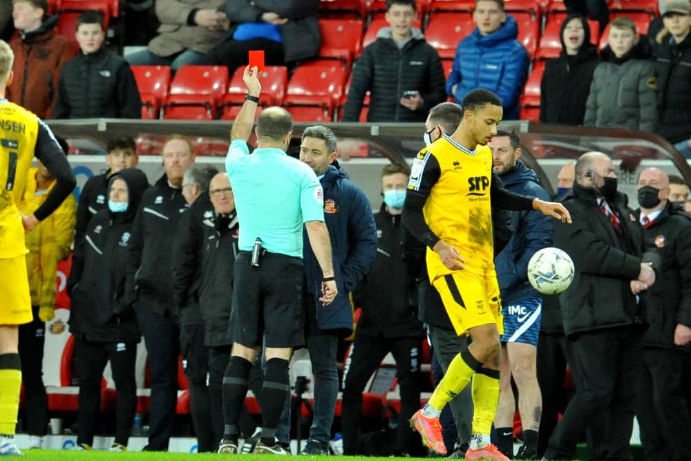 Lee Johnson is shown a red card earlier this year