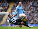 Erling Haaland of Manchester City is tackled by Jamaal Lascelles of Newcastle United during the Premier League match between Manchester City and Newcastle United at Etihad Stadium on March 04, 2023 in Manchester, England. (Photo by Laurence Griffiths/Getty Images)