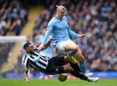 Erling Haaland of Manchester City is tackled by Jamaal Lascelles of Newcastle United during the Premier League match between Manchester City and Newcastle United at Etihad Stadium on March 04, 2023 in Manchester, England. (Photo by Laurence Griffiths/Getty Images)