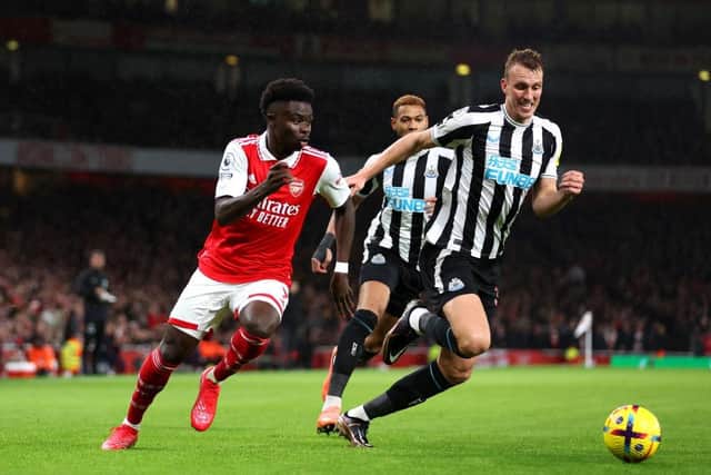 Bukayo Saka of Arsenal battles for possession with Dan Burn of Newcastle United during the Premier League match between Arsenal FC and Newcastle United at Emirates Stadium on January 03, 2023 in London, England. (Photo by Julian Finney/Getty Images)