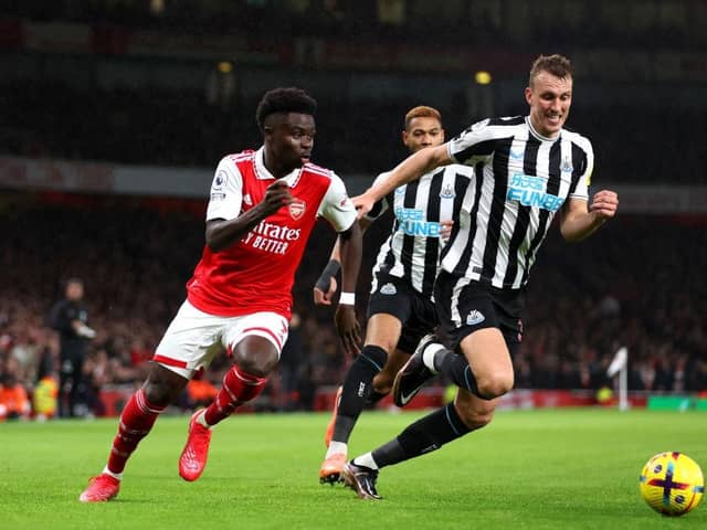Bukayo Saka of Arsenal battles for possession with Dan Burn of Newcastle United during the Premier League match between Arsenal FC and Newcastle United at Emirates Stadium on January 03, 2023 in London, England. (Photo by Julian Finney/Getty Images)