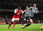 Bukayo Saka of Arsenal battles for possession with Dan Burn of Newcastle United during the Premier League match between Arsenal FC and Newcastle United at Emirates Stadium on January 03, 2023 in London, England. (Photo by Julian Finney/Getty Images)