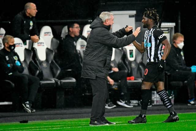 Newcastle United's French midfielder Allan Saint-Maximin (R) celebrates scoring the opening goal with Newcastle United's English head coach Steve Bruce (C) during the English Premier League football match between Newcastle United and Burnley at St James' Park in Newcastle-upon-Tyne, north east England on October 3, 2020.