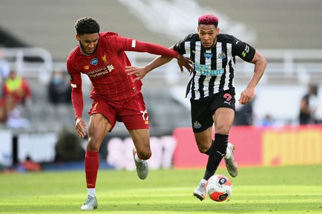 Joe Gomez of Liverpool battles for possession with Joelinton of Newcastle United during the Premier League match between Newcastle United and Liverpool FC at St. James Park on July 26, 2020 in Newcastle upon Tyne, England.