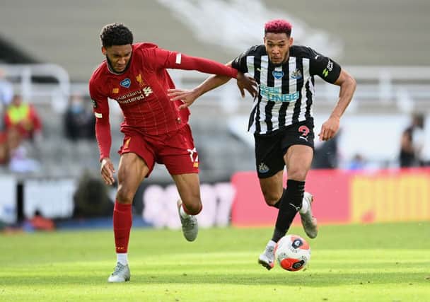 Joe Gomez of Liverpool battles for possession with Joelinton of Newcastle United during the Premier League match between Newcastle United and Liverpool FC at St. James Park on July 26, 2020 in Newcastle upon Tyne, England.