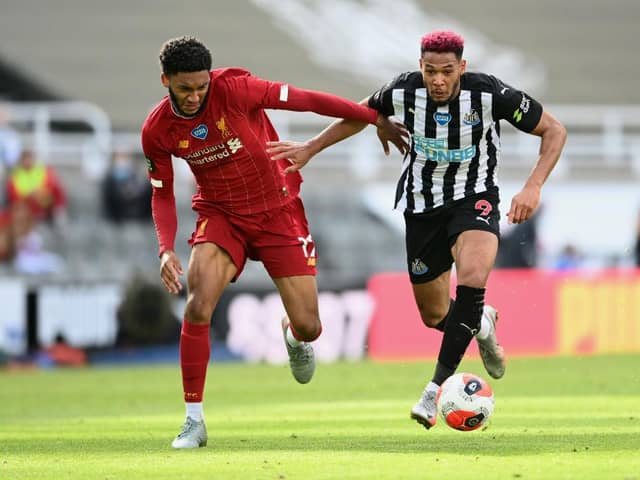 Joe Gomez of Liverpool battles for possession with Joelinton of Newcastle United during the Premier League match between Newcastle United and Liverpool FC at St. James Park on July 26, 2020 in Newcastle upon Tyne, England.