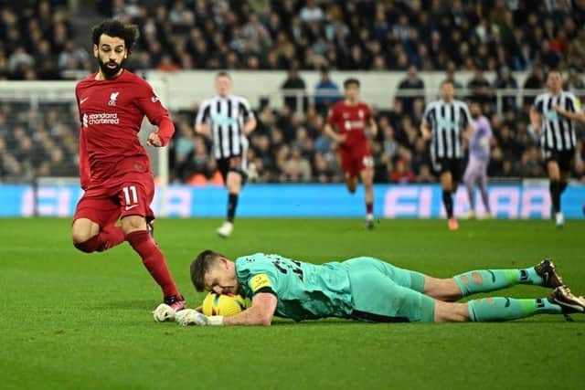 Liverpool's Egyptian striker Mohamed Salah (L) fights for the ball with Newcastle United's English goalkeeper Nick Pope (R) during the English Premier League football match between Newcastle United and Liverpool at St James' Park in Newcastle-upon-Tyne, north east England on February 18, 2023. (Photo by OLI SCARFF/AFP via Getty Images)