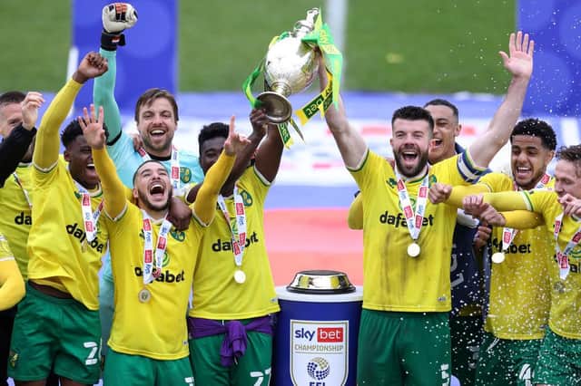 Alexander Tettey and Grant Hanley of Norwich City lift the Sky Bet Championship trophy.