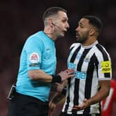 Referee David Coote speaks with Newcastle United striker Callum Wilson.
