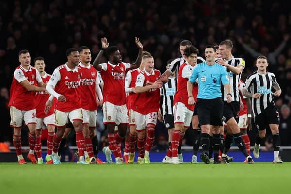 Arsenal players surround the Referee Andy Madley after a late penalty appeal (Photo by Julian Finney/Getty Images)