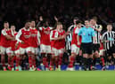 Arsenal players surround the Referee Andy Madley after a late penalty appeal (Photo by Julian Finney/Getty Images)