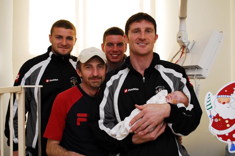 Barnsley F.C. players visited children at Barnsley District General Hospital in 2009.
Eight weeks old  Grace Cook gets a hug from players, from left, Carl Dickinson, Adam Hammill, John  Macken with dad  Norman Cook (second left) looking on.