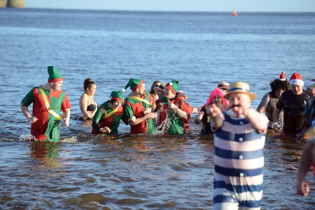 Fundraisers dressed as Santa's elves embracing the North Sea cold