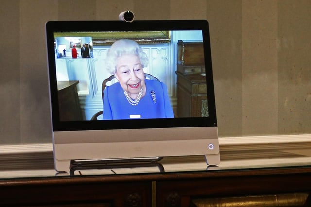 Queen Elizabeth II appearing on a screen by videolink from Windsor Castle, where she is in residence, during a virtual audience to receive His Excellency the Ambassador of Germany Andreas Michaelis and his wife Heike Michaelis, who were at London's Buckingham Palace. 10/12/20
