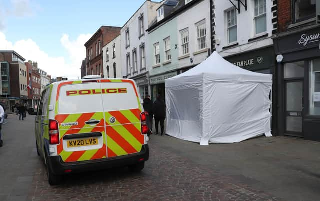 A police tent outside The Clean Plate cafe in Southgate Street, Gloucester.