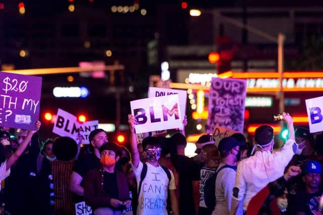 People shout slogans and hold placards, on June 1, 2020, in downtown Las Vegas, as they take part in a "Black lives matter" rally in response to the recent death of George Floyd, an unarmed black man who died while in police custody.