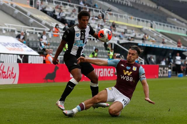 Newcastle's Isaac Hayden battles for possession with Aston Villa's Jack Grealish.