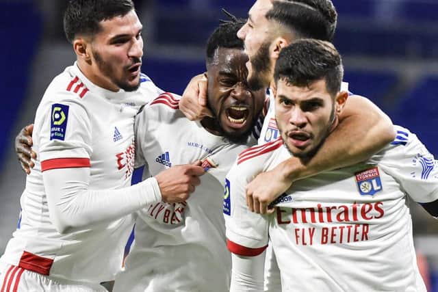 Lyon's Ivorian forward Maxwel Cornet (2nd-L) celebrates with Lyon's French midfielder Houssem Aouar (L), Lyon's French forward Rayan Cherki (2nd-R) and Lyon's Brazilian midfielder Bruno Guimaraes (R) after scoring a goal during the French L1 football match between Olympique Lyonnais and Le Stade Brestois 29 at the Groupama stadium in Decines-Charpieu, near Lyon, south-eastern France, on December 16, 2020. (Photo by PHILIPPE DESMAZES / AFP) (Photo by PHILIPPE DESMAZES/AFP via Getty Images)