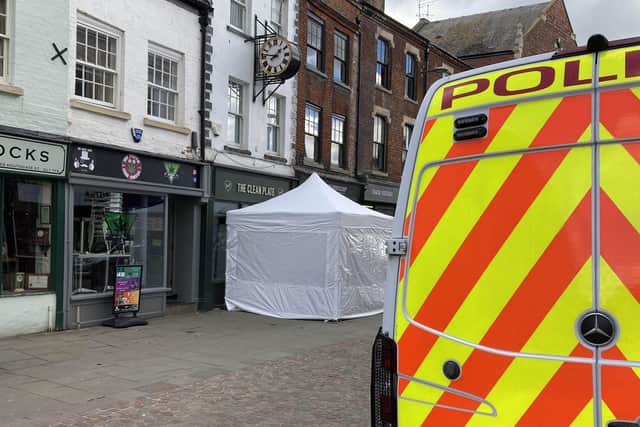 A police tent outside The Clean Plate cafe in Southgate Street, Gloucester.