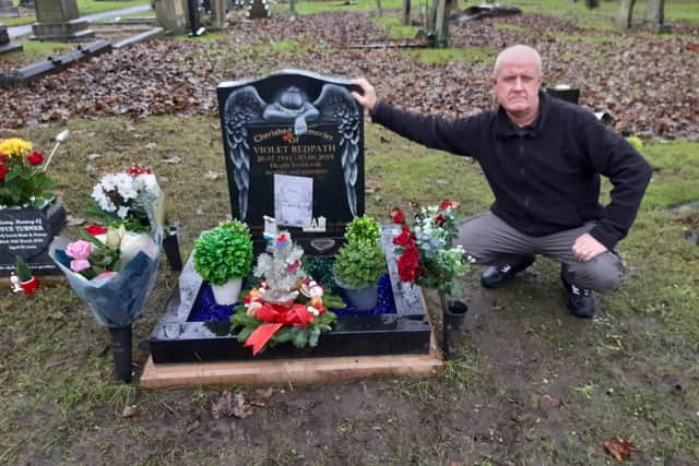 Anthony Redpath alongside his mother Violet's grave which has been targeted by thieves and vandals.