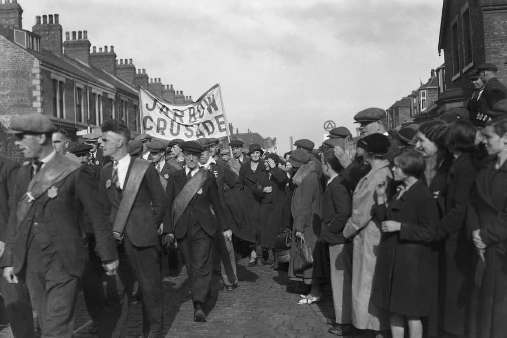 The Jarrow March passes through a town in the North East in October 1936 on their way to Parliament to hand in a petition and protest the mass unemployment. Photo by Central Press/Hulton Archive/Getty Images