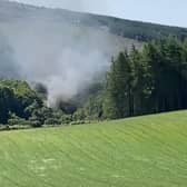 Screen grab from BBC Scotland showing smoke billowing from the train on the track in the countryside near Stonehaven, Aberdeenshire . Emergency services are at the scene after a train derailed in Aberdeenshire.