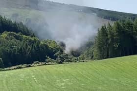 Screen grab from BBC Scotland showing smoke billowing from the train on the track in the countryside near Stonehaven, Aberdeenshire . Emergency services are at the scene after a train derailed in Aberdeenshire.