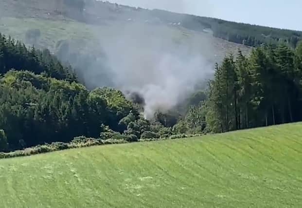 Screen grab from BBC Scotland showing smoke billowing from the train on the track in the countryside near Stonehaven, Aberdeenshire . Emergency services are at the scene after a train derailed in Aberdeenshire.
