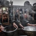 Displaced Palestinian children gather to receive food at a government school in Rafah in the southern Gaza Strip (Picture: Mohammed Abed/AFP via Getty Images)