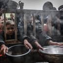 Displaced Palestinian children gather to receive food at a government school in Rafah in the southern Gaza Strip (Picture: Mohammed Abed/AFP via Getty Images)