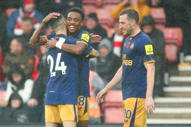 Joe Willock celebrates with Miguel Almiron of Newcastle United after scoring their team's third goal during the Premier League match between Southampton FC and Newcastle United at Friends Provident St. Mary's Stadium on November 06, 2022 in Southampton, England. (Photo by Charlie Crowhurst/Getty Images)