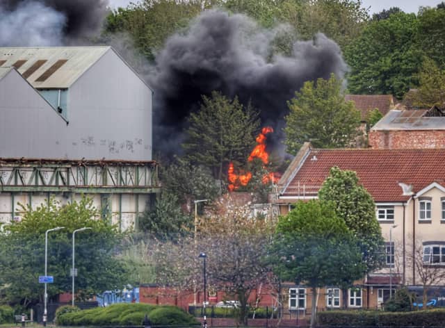 Large plumes of black smoke can be seen rising from the fire.