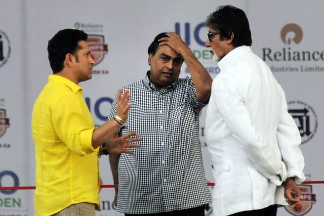 Former Indian cricketer Sachin Tendulkar (L), Indian industrialist Mukesh Ambani (Chairman of Reliance Industries) (C) and Bollywood actor Amitabh Bachchan (R) (Photo credit should read STRDEL/AFP via Getty Images)
